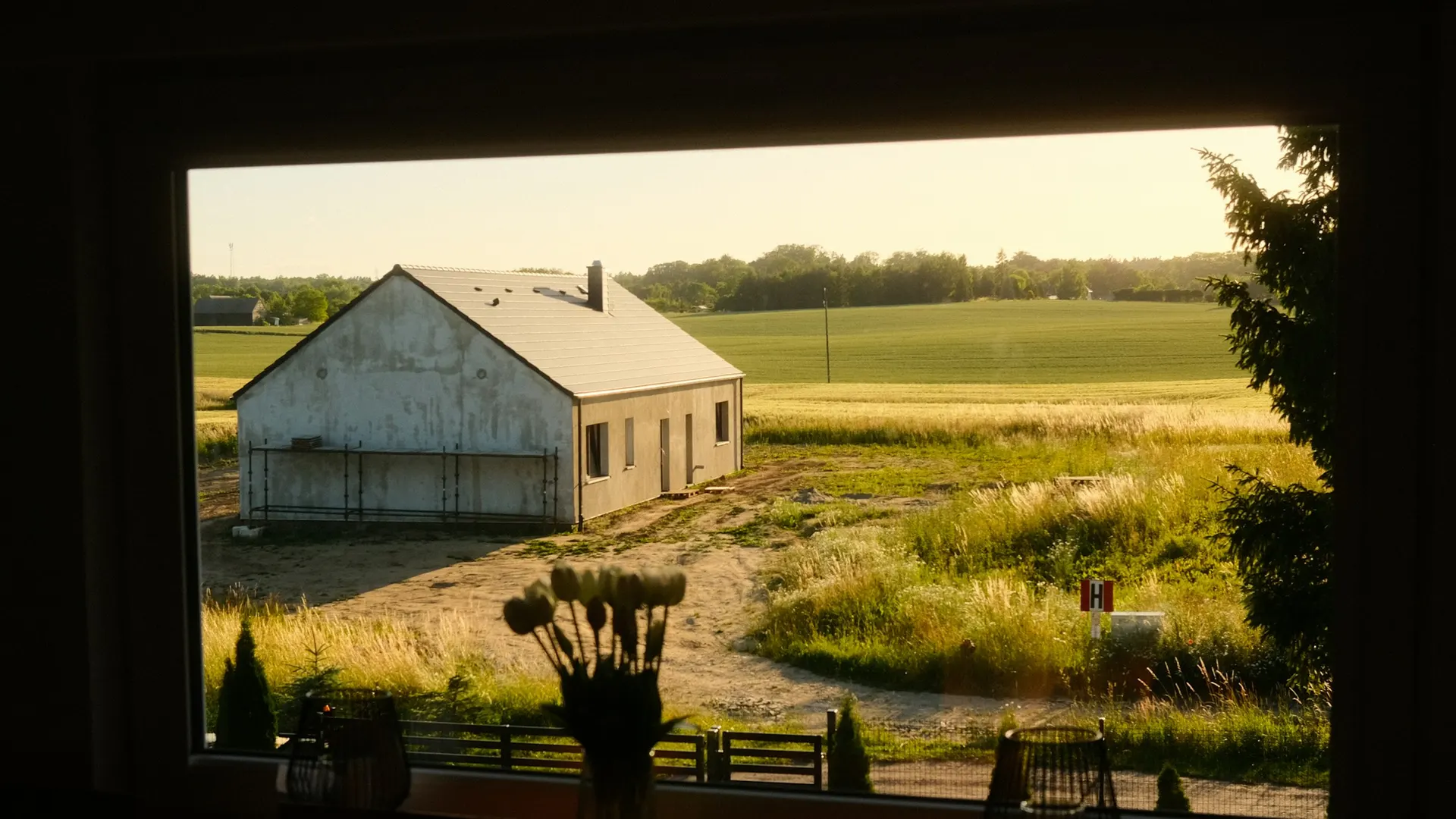 Blank ruled notebook on a desk beside a window onto fields, no text visible